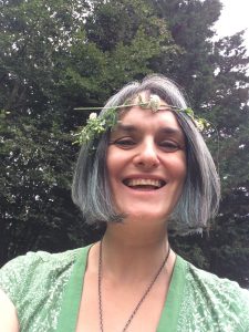 Annastasia Ward wearing flower garland with trees in background